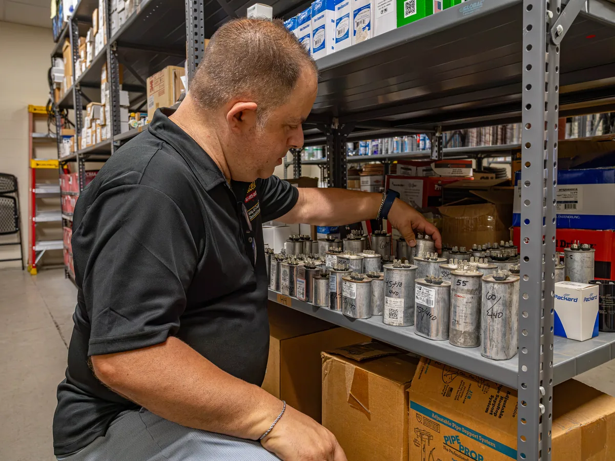 Wentzel's team member pulling a capacitor from the parts shelves at the Sarasota warehouse