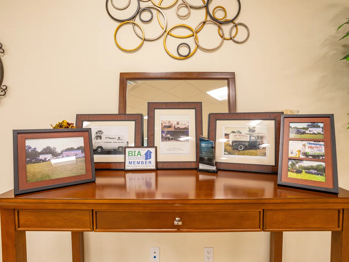 Framed photos of early Wentzel's trucks and job sites on display at the Sarasota office
