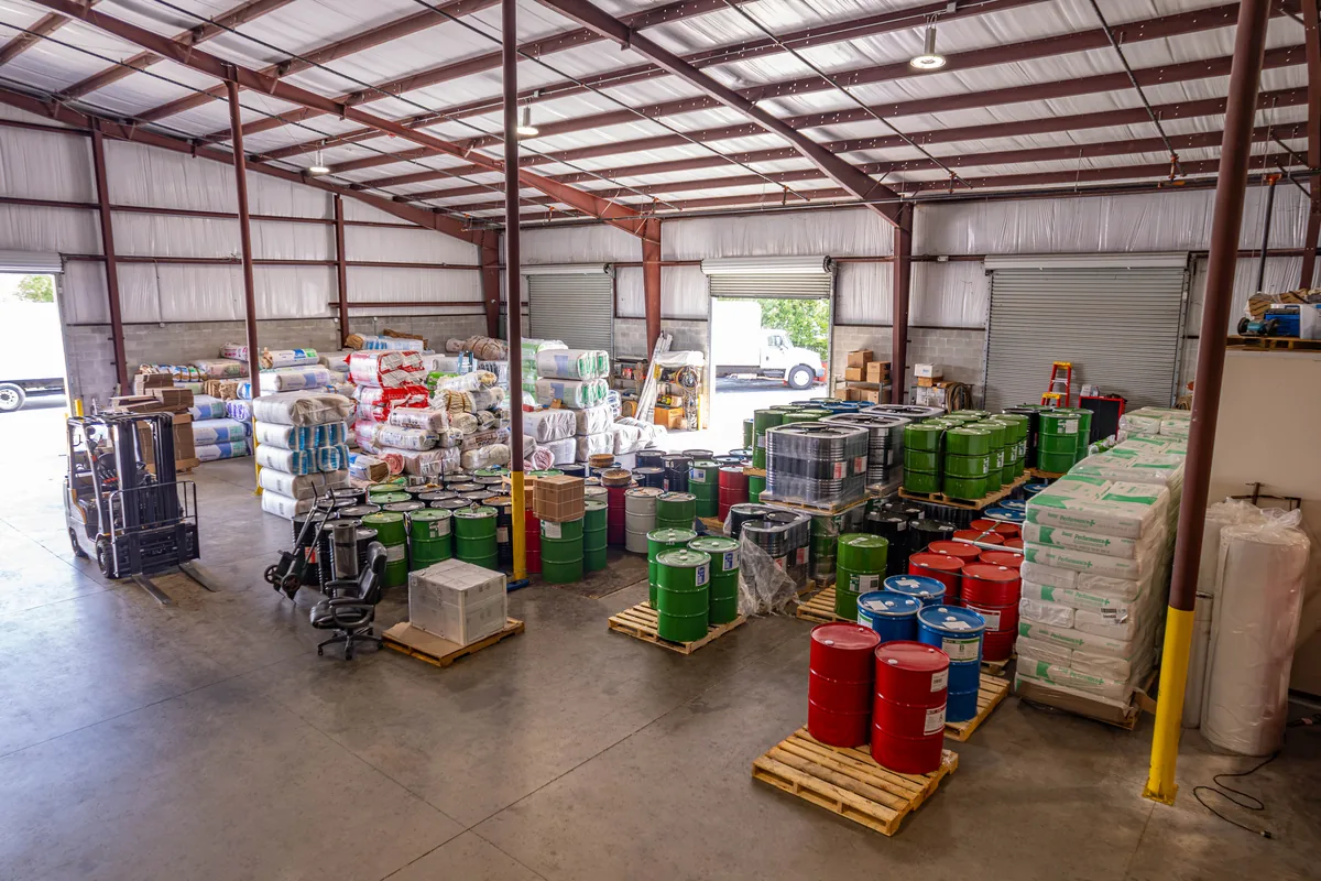 Spray foam drums and bags of insulation stocked inside Wentzel's Sarasota warehouse