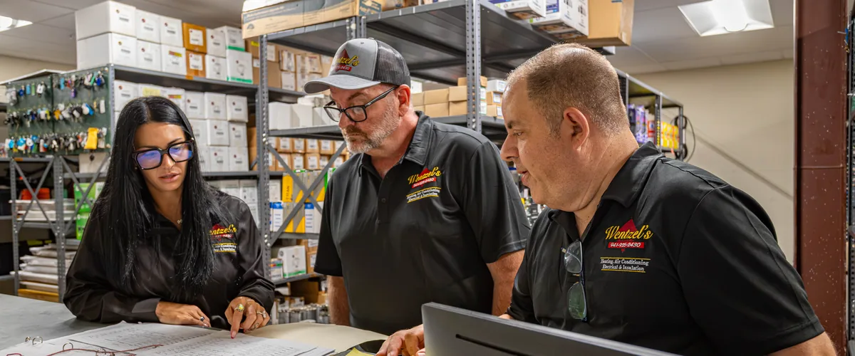 Wentzel's team members going over a job ticket at the parts counter in Sarasota