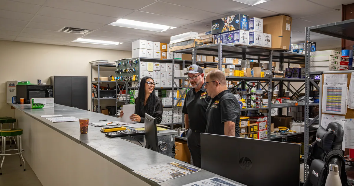 Wentzel's team members going over paperwork at the parts counter in Sarasota