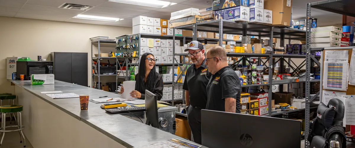 Wentzel's team members going over paperwork together at the parts counter in Sarasota