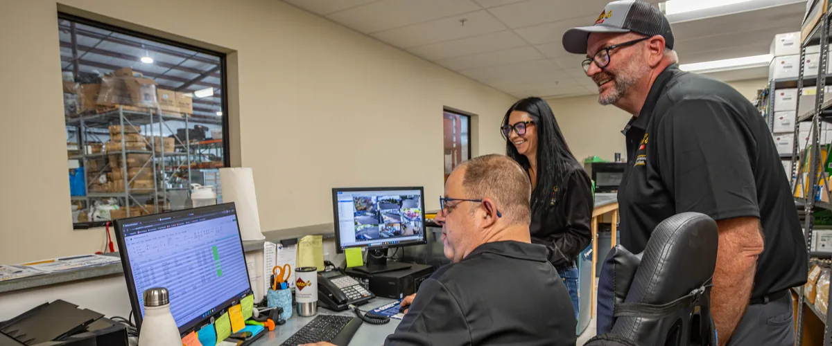 Wentzel's team members checking a job on the computer in the parts office at the Sarasota headquarters