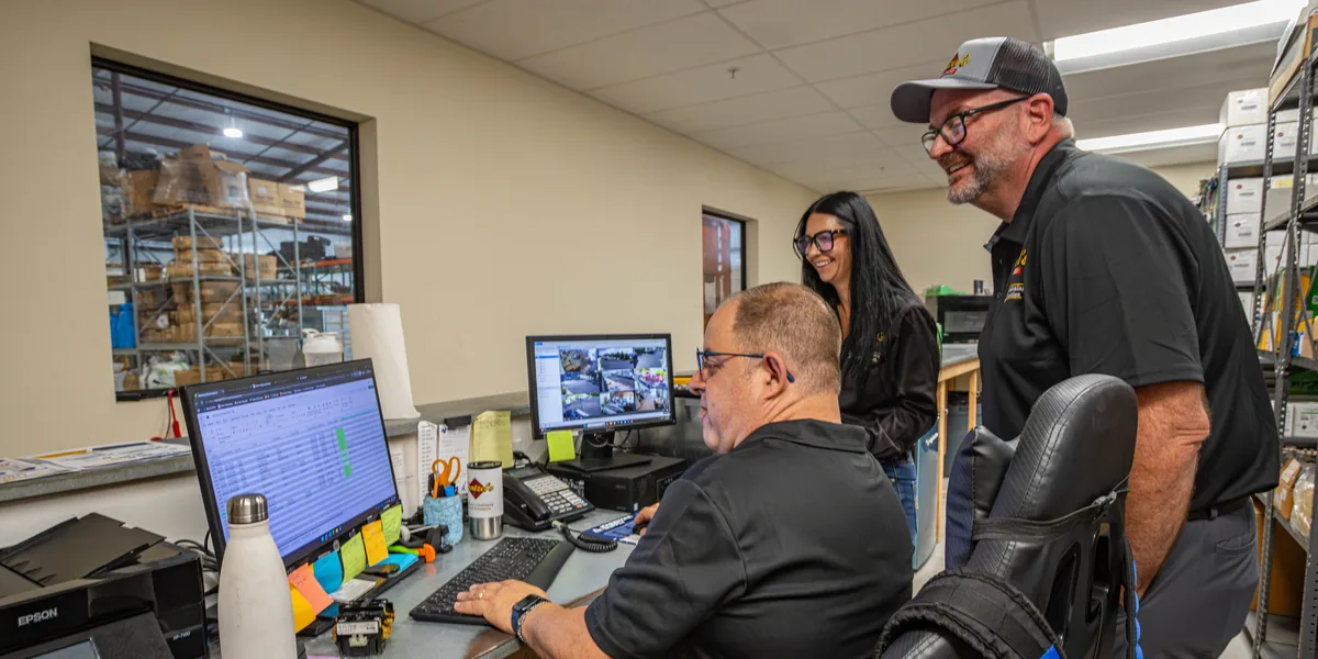 Wentzel's team members looking over a job on the computer in the parts office at the Sarasota headquarters